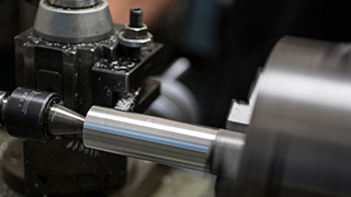 A block of metal is being turned into a cone at a lathe.